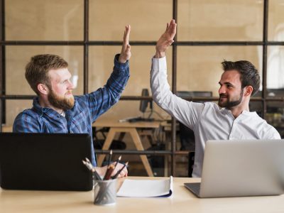 two-successful-male-colleague-giving-high-five-office (1)